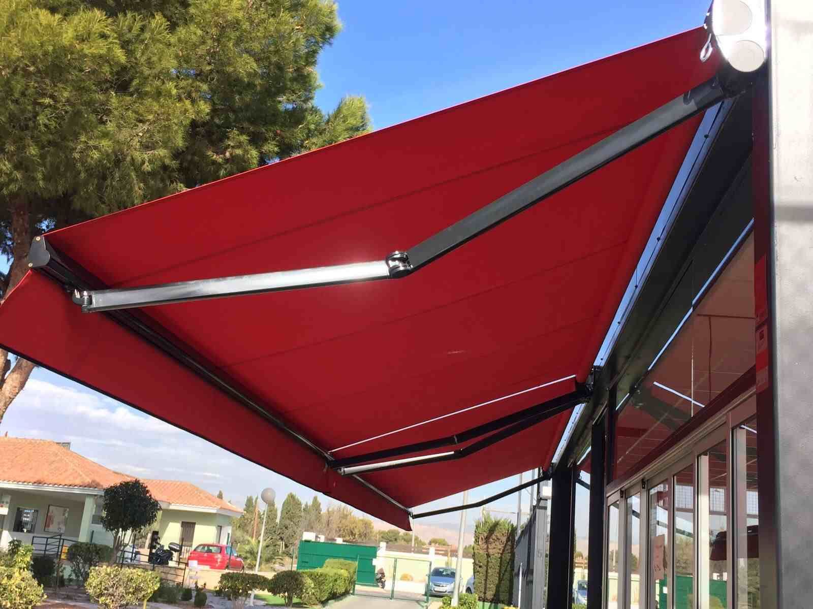 Un toldo rojo cubre el costado de un edificio.