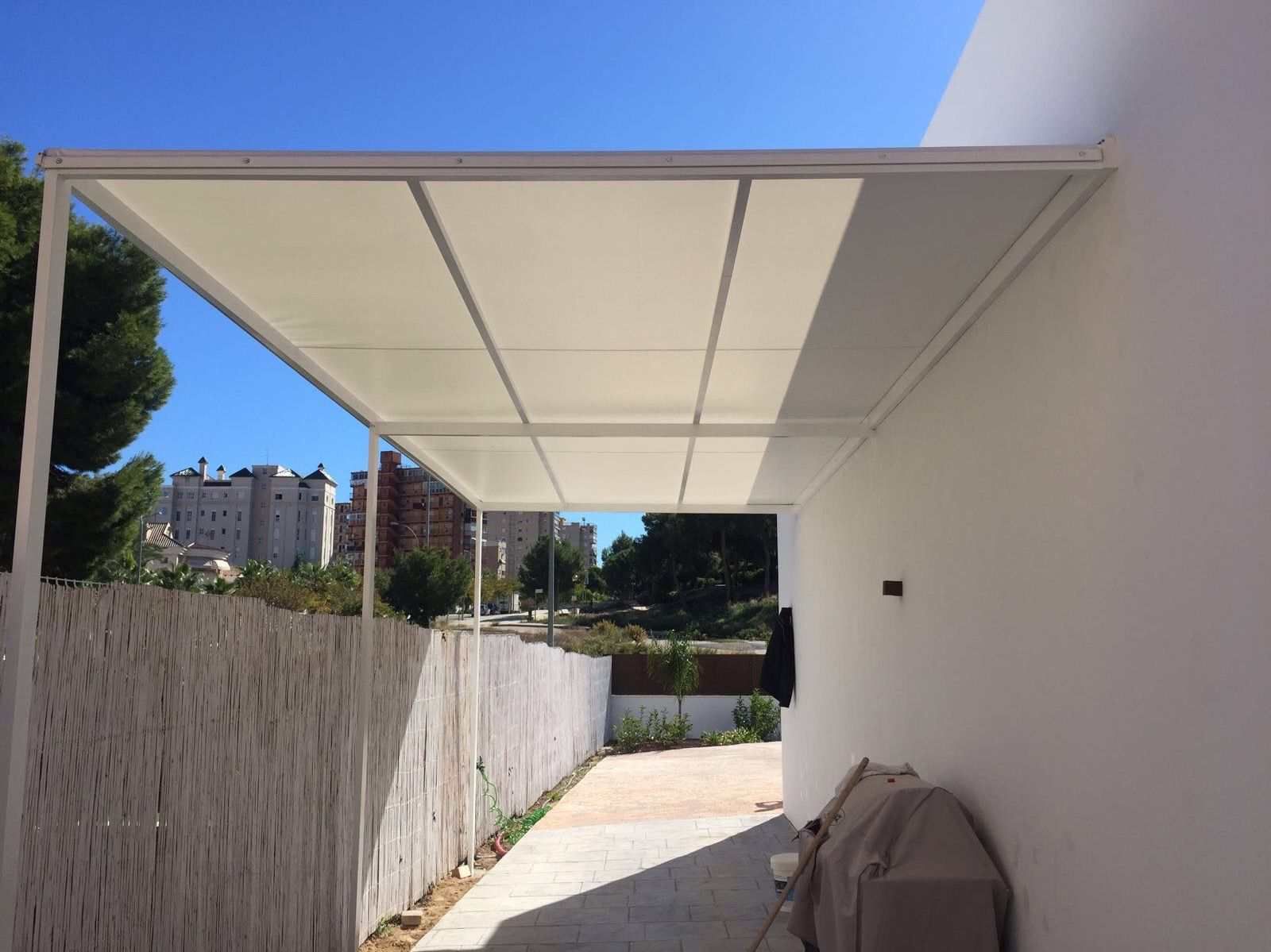 Un edificio blanco con un dosel sobre un camino de entrada.