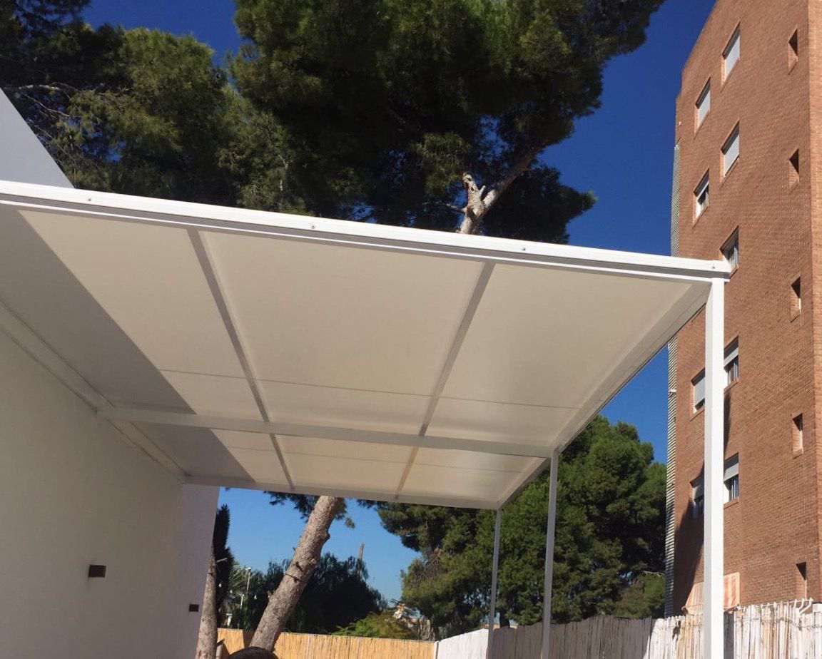 Un dosel blanco con un edificio de ladrillo al fondo