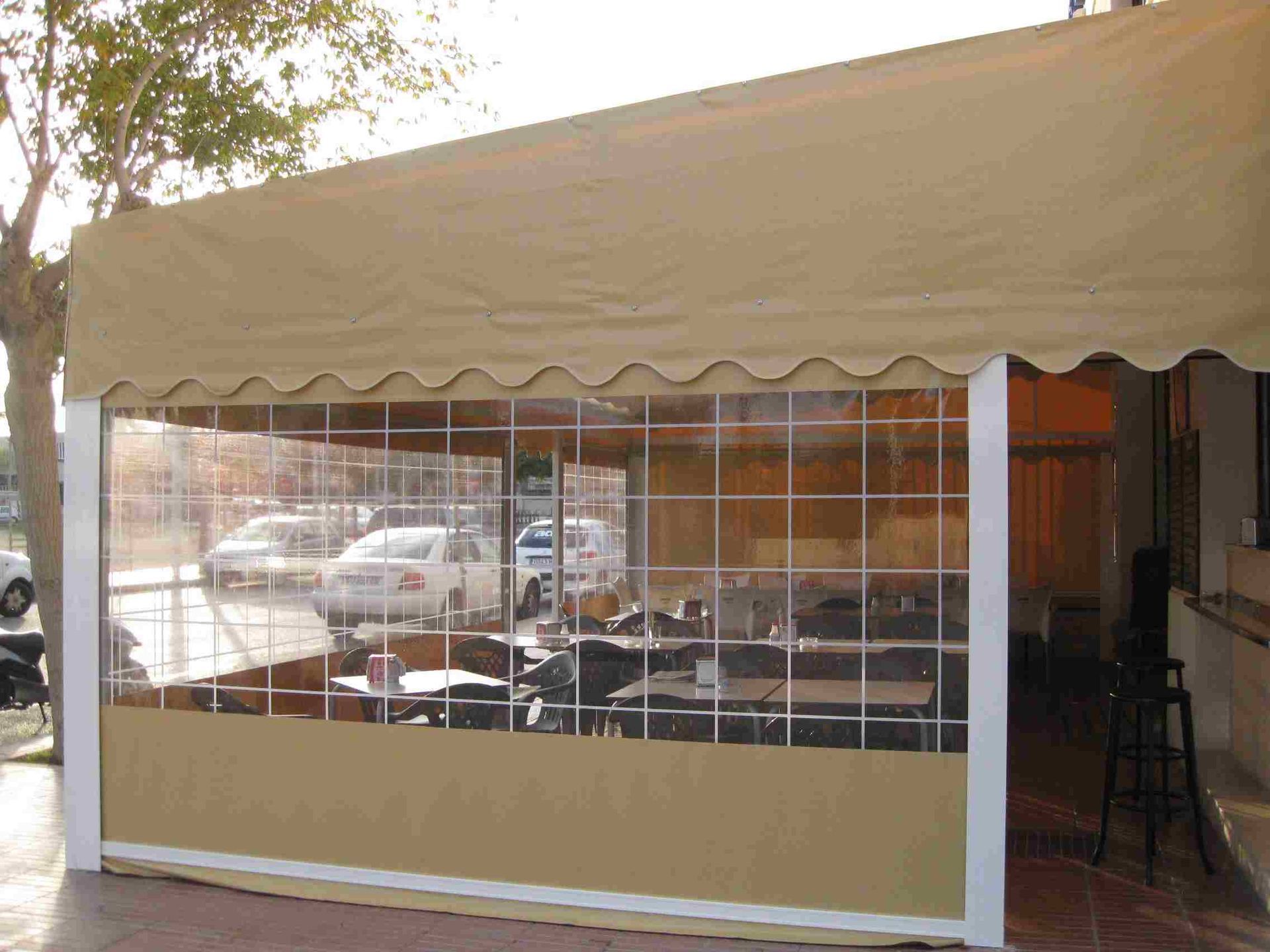 Una carpa con mesas y sillas debajo.