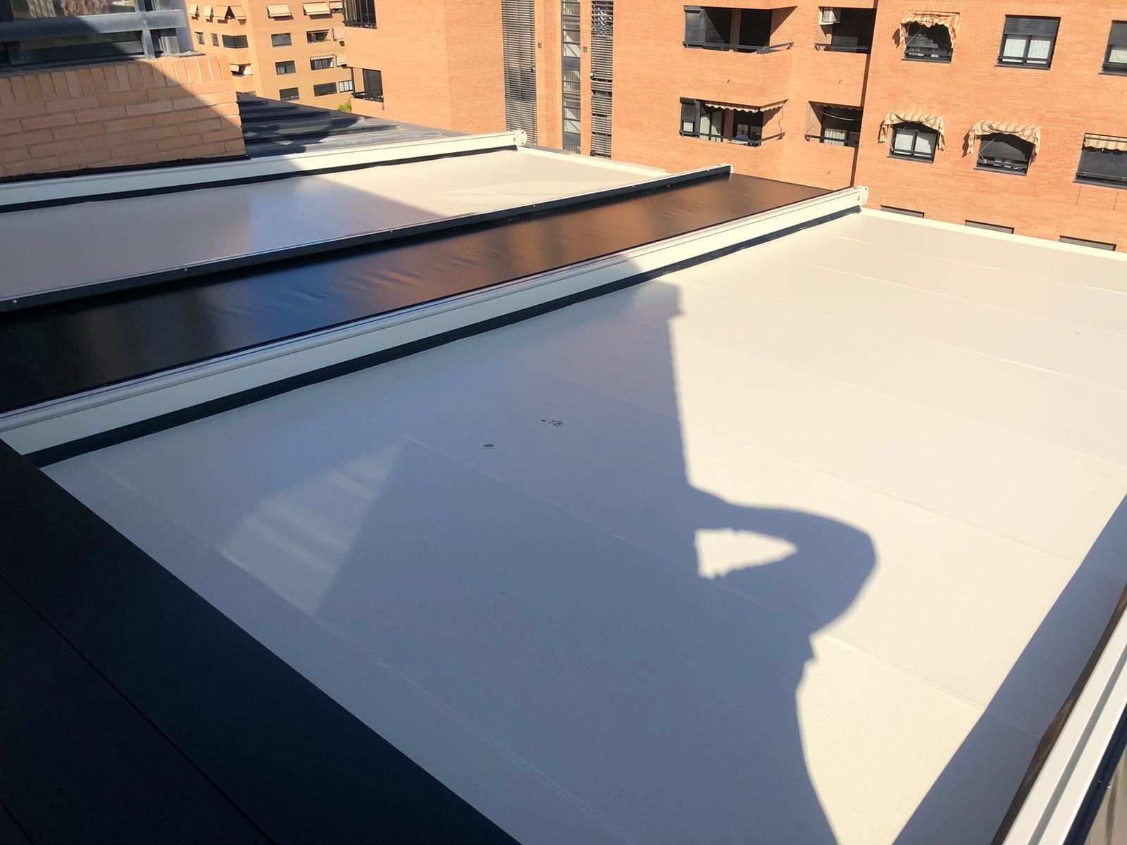 La sombra de una persona se proyecta sobre el tejado de un edificio.