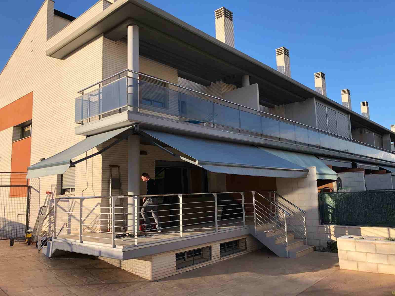 Un hombre está de pie en el balcón de una casa.