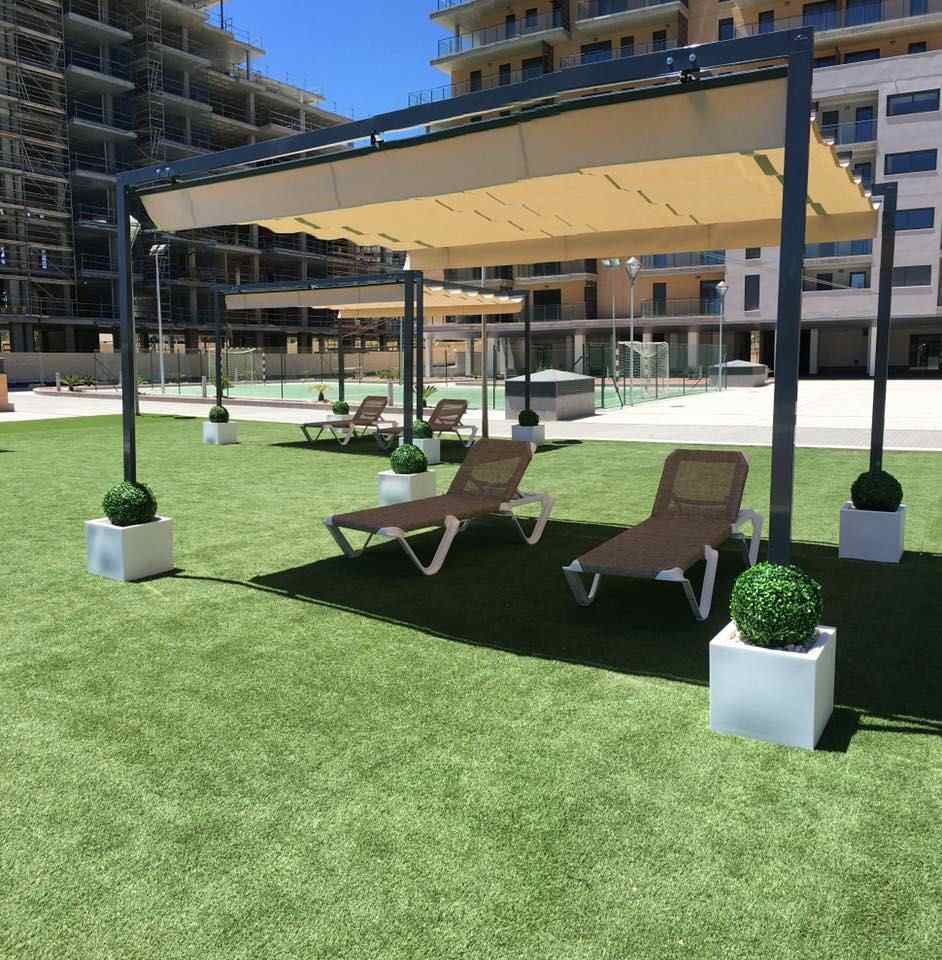 Sillas de jardín bajo una sombrilla en un día soleado