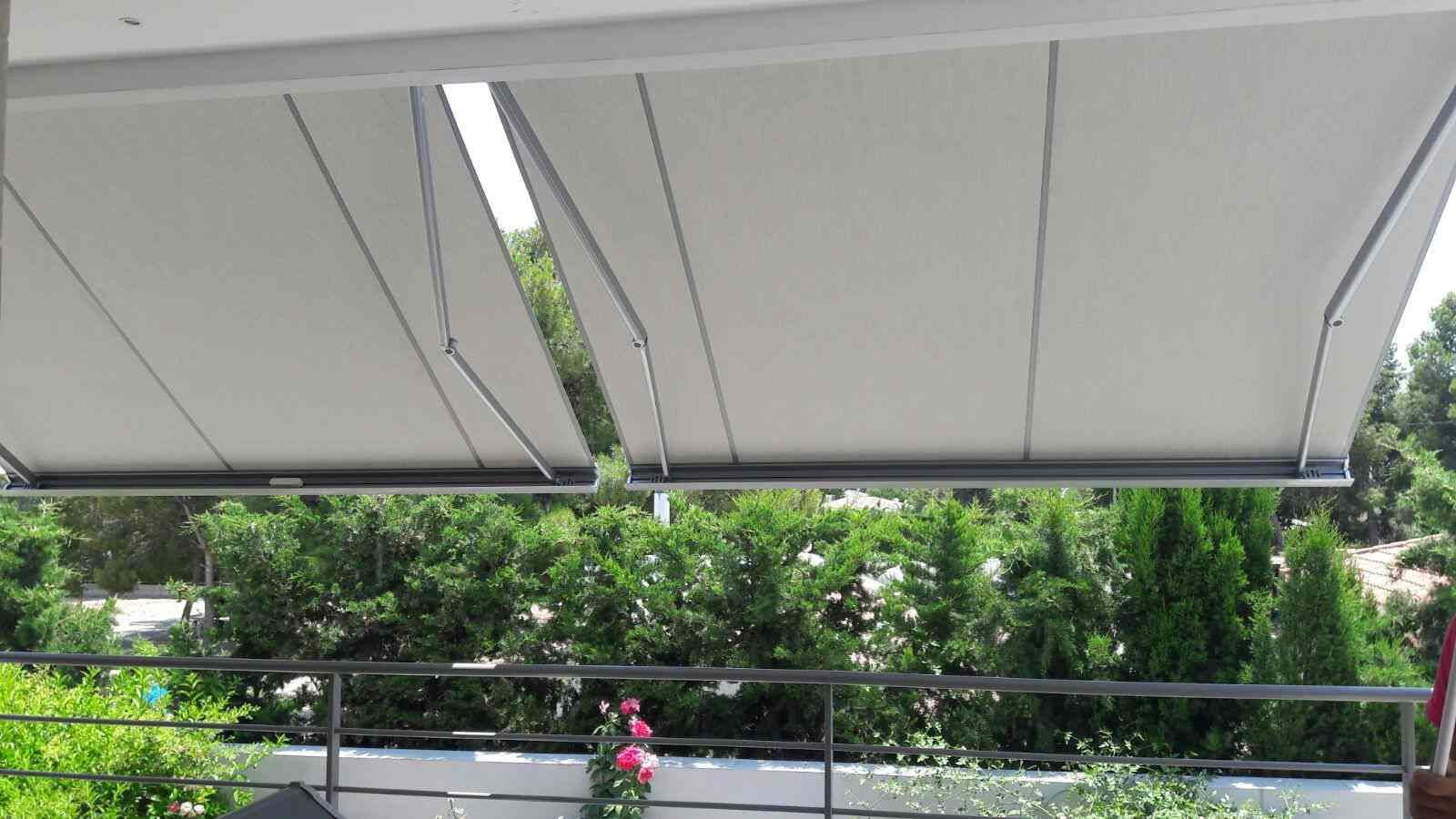 Un toldo blanco cuelga del techo de un balcón.