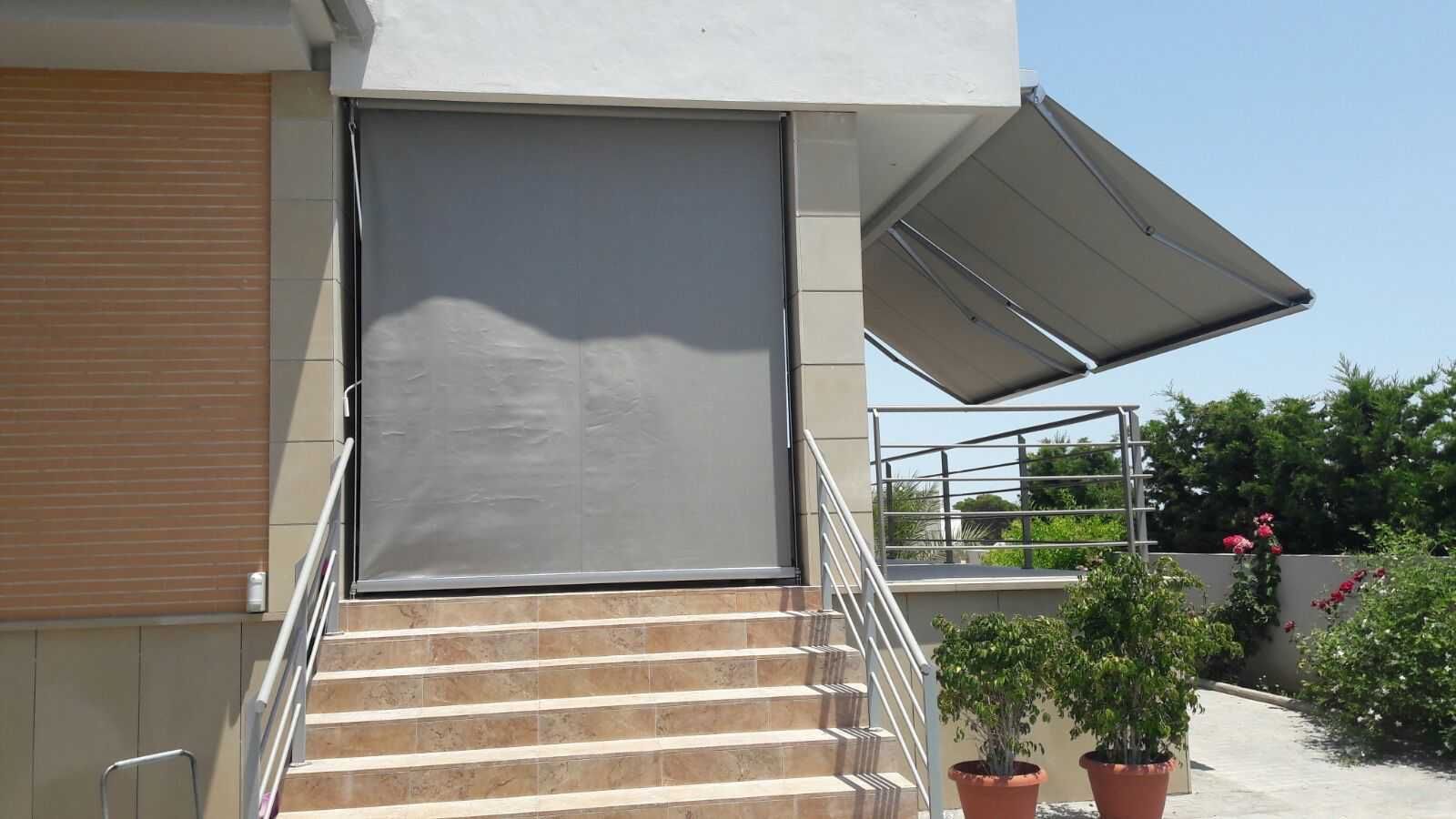 Una escalera que conduce a un edificio con un toldo gris encima.