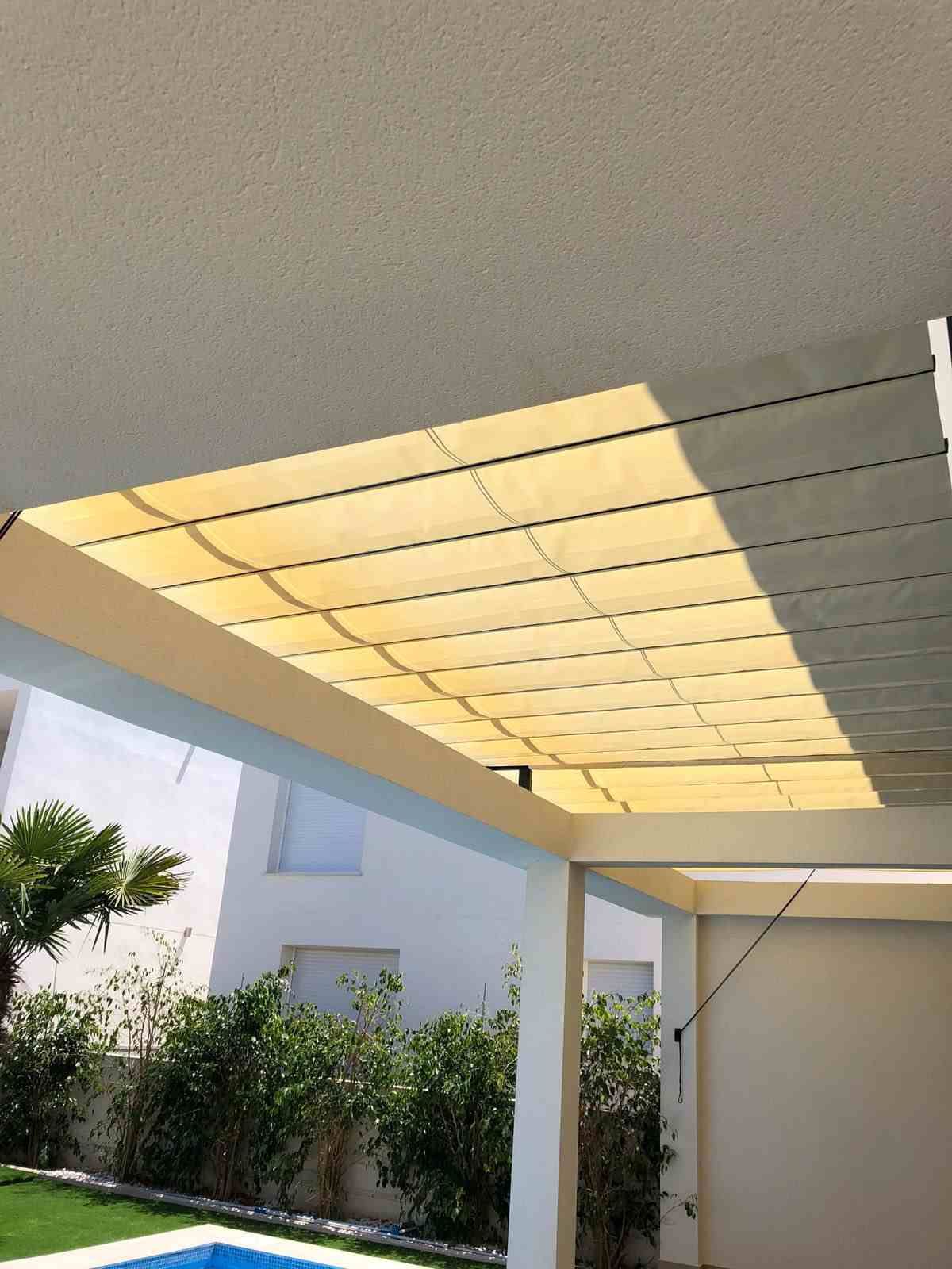 Un patio con un techo cubierto con una sombra.