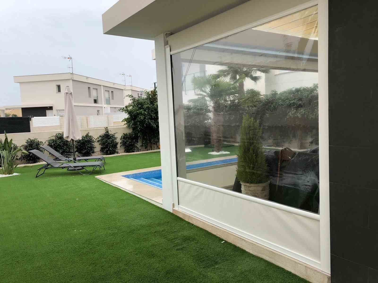 Hay una piscina en el patio trasero de una casa.