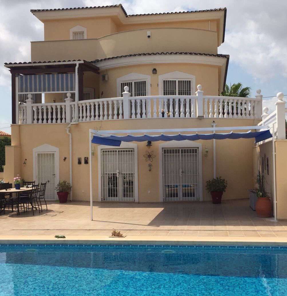 Una casa grande con piscina delante de ella.