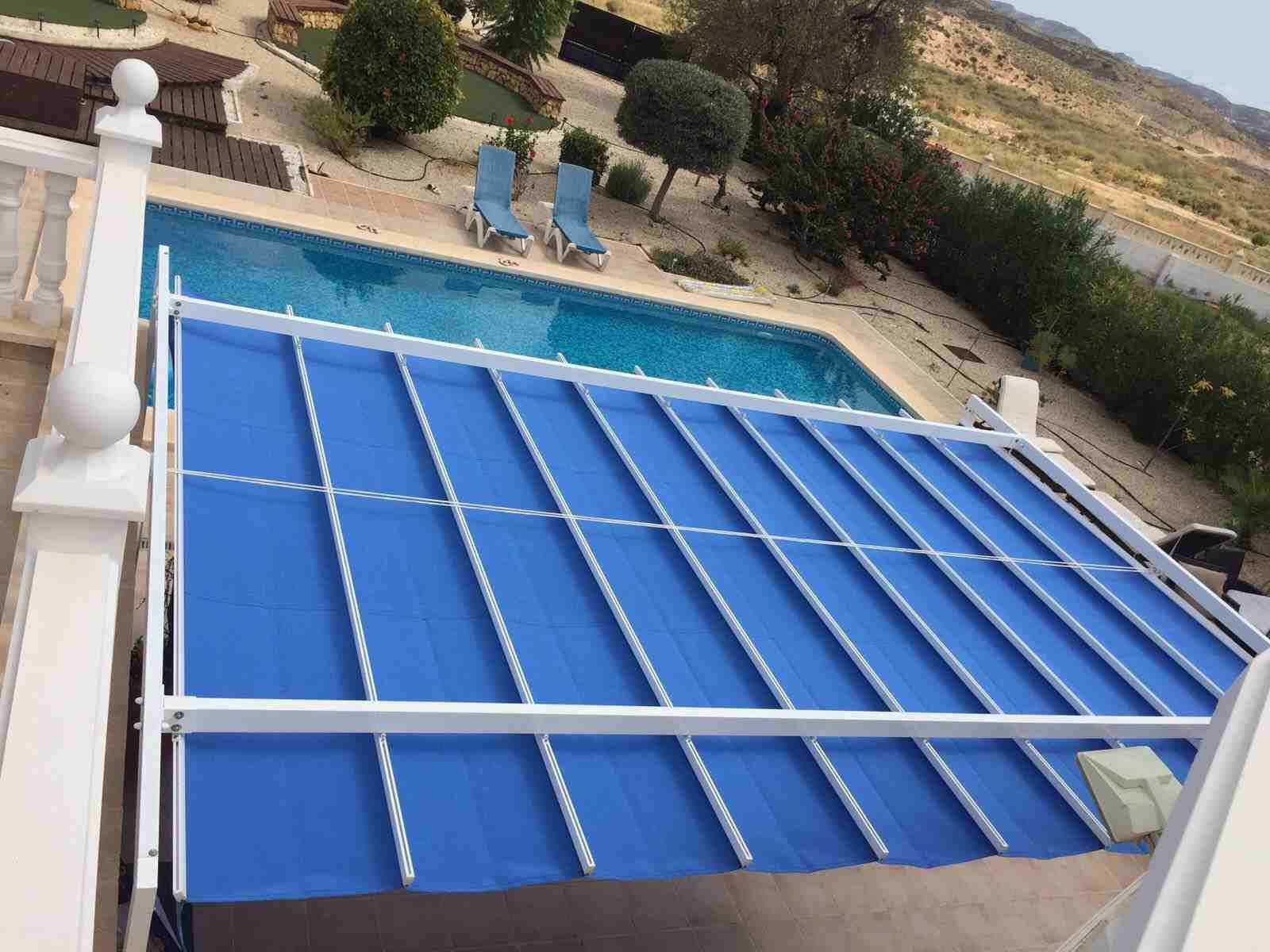 Una piscina con un toldo azul encima