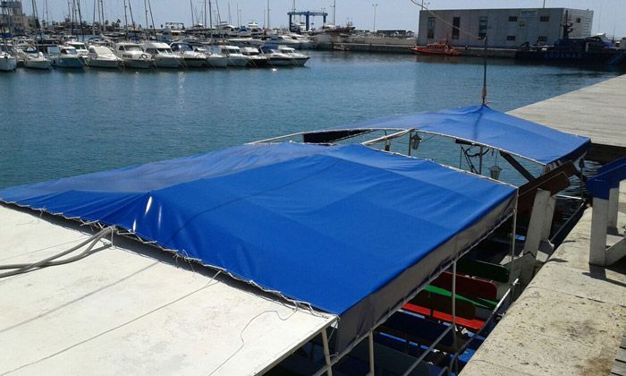 Una lona azul cubre un barco en un puerto.