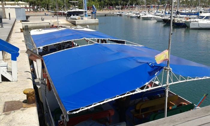 Un barco con un dosel azul está atracado en un puerto