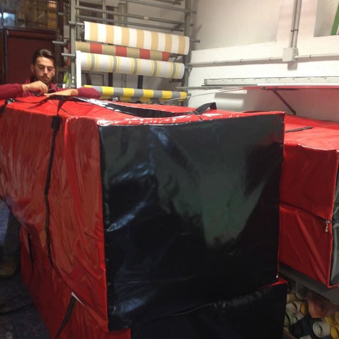 Un hombre está de pie junto a una gran caja roja y negra.