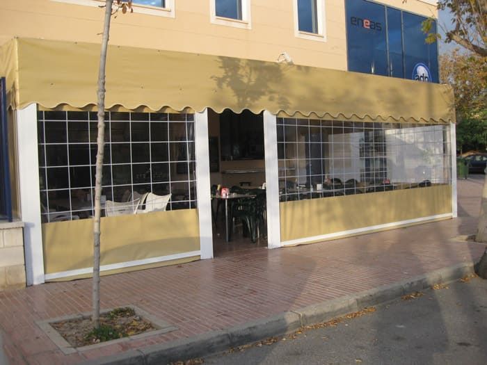 Un restaurante con mesas y sillas bajo un toldo.