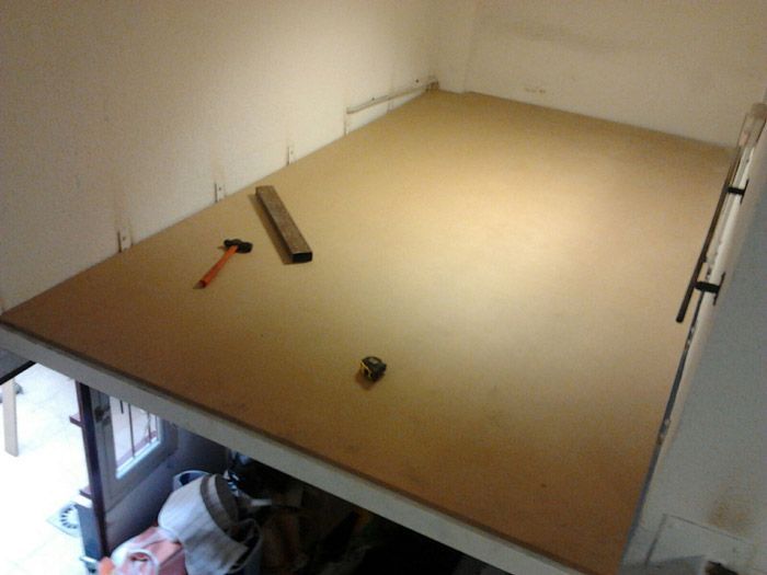 Un piso de madera con un martillo y una regla sobre él.