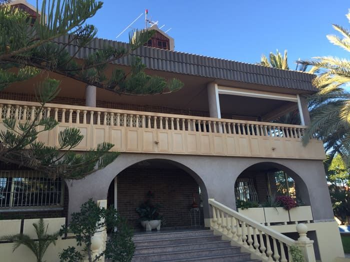 Una casa grande con balcón y escaleras que conducen hasta ella.