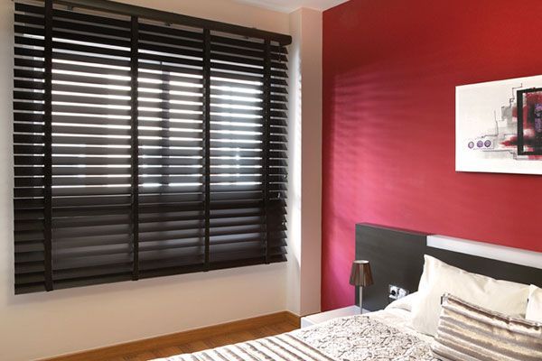 Un dormitorio con una cama y una ventana con persianas.