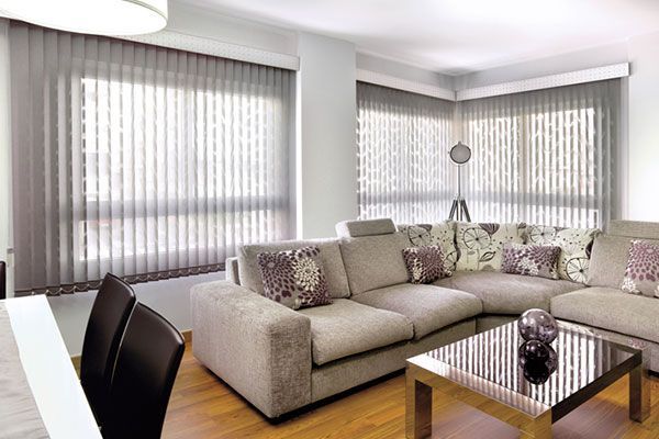 Una sala de estar con sofá, mesa, sillas y persianas.