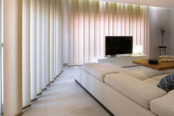 Una sala de estar con sofá, mesa, sillas y persianas.