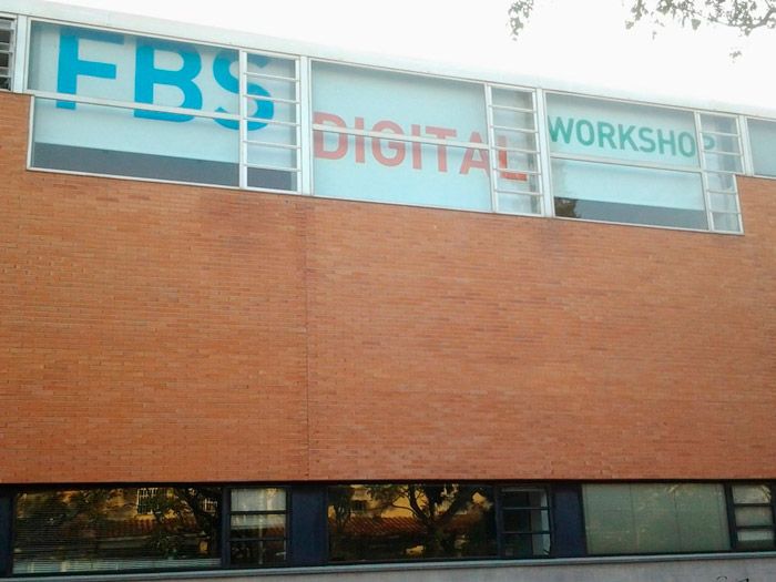 Un edificio de ladrillos con un cartel que dice taller digital frs