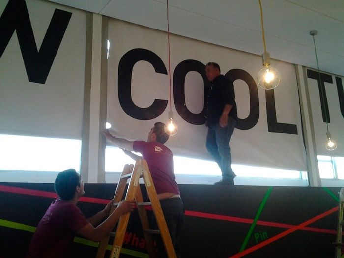 Dos hombres están trabajando en un cartel que dice 