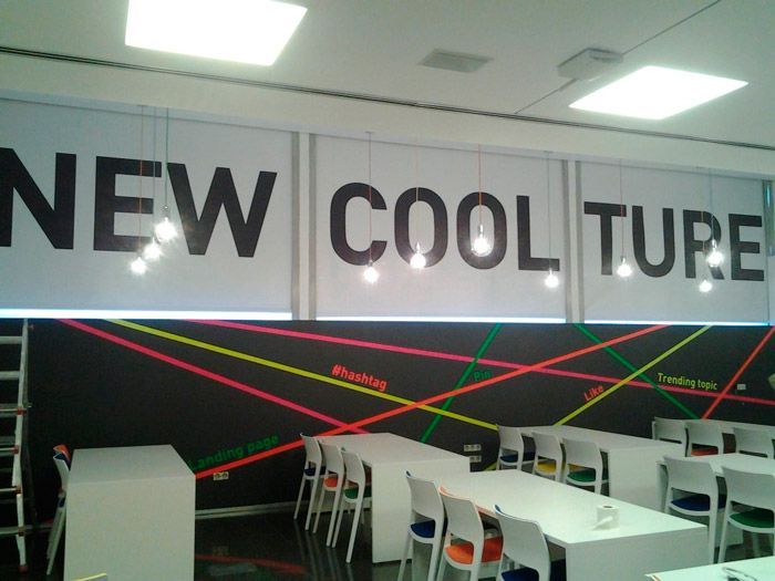 Una habitación con mesas y sillas y un cartel que dice nueva moda cool