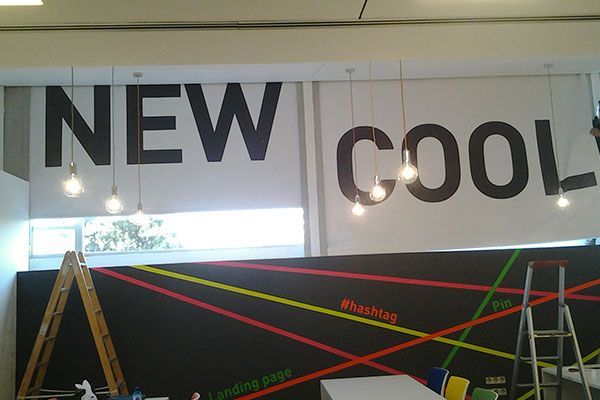 Un comedor con mesa y sillas y un gran ventanal con persianas blancas.