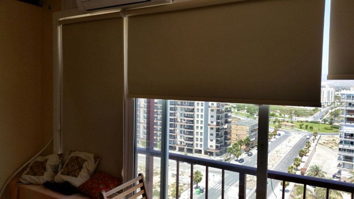 Un dormitorio con balcón y vista a la ciudad.