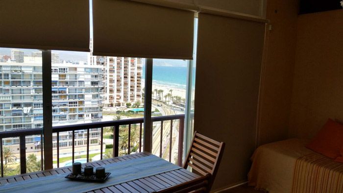 Una habitación con mesa y sillas y un balcón con vista al mar.