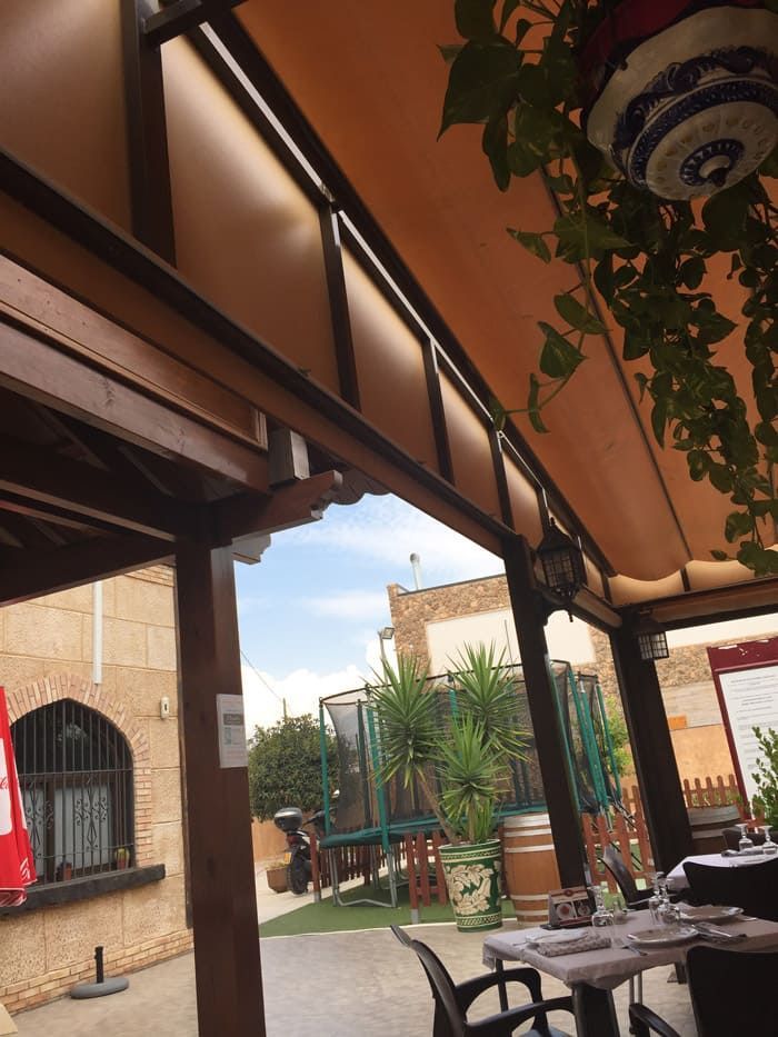 Un restaurante con mesas y sillas bajo un toldo.