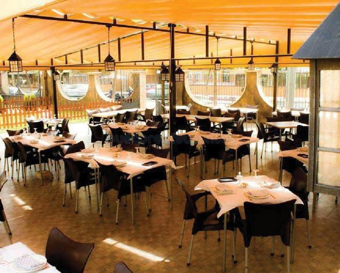 Un restaurante con mesas y sillas bajo un dosel.