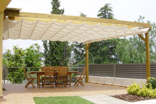 Un patio con una mesa y sillas bajo un dosel.