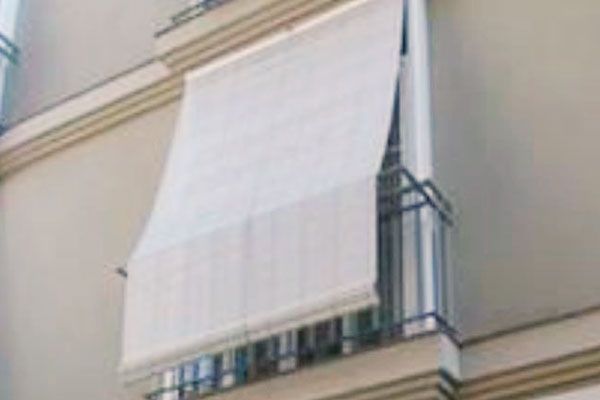 Un rollo de persianas de bambú cuelga en una pared blanca.