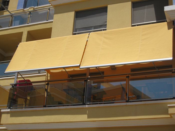 Un balcón con un toldo amarillo encima.