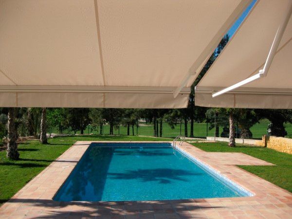 Una gran piscina con un toldo blanco encima.