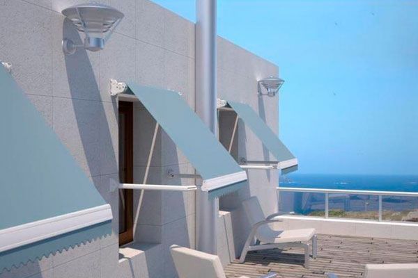 Un toldo blanco cuelga sobre una ventana de un edificio de ladrillo.
