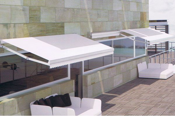 Un balcón con un toldo naranja y una barandilla blanca.