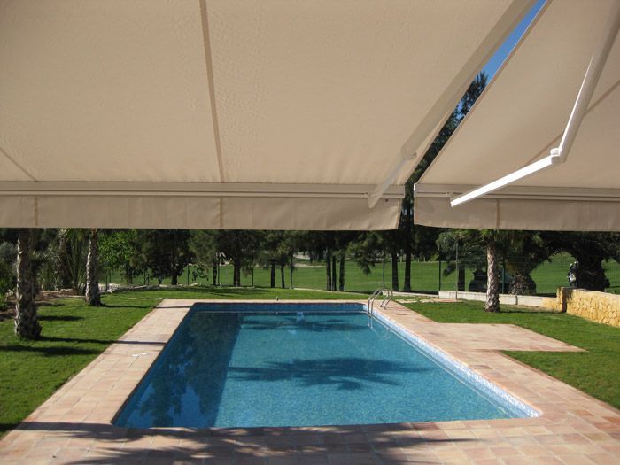 Una gran piscina con un toldo blanco encima.