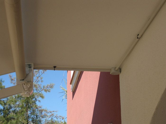 Un toldo blanco está fijado al costado de un edificio.