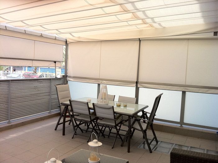 Un patio con una mesa y sillas bajo un dosel.