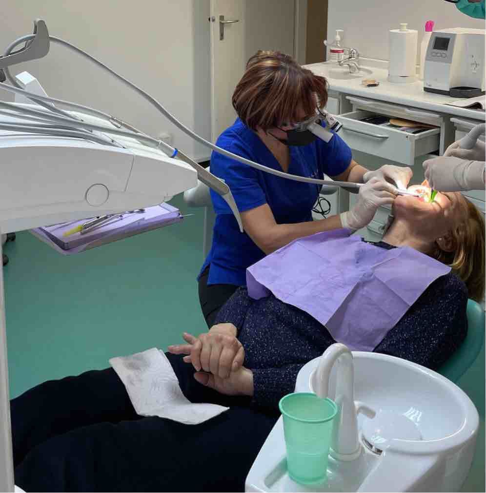 Paziente donna (40+) durante un trattamento estetico dentale.