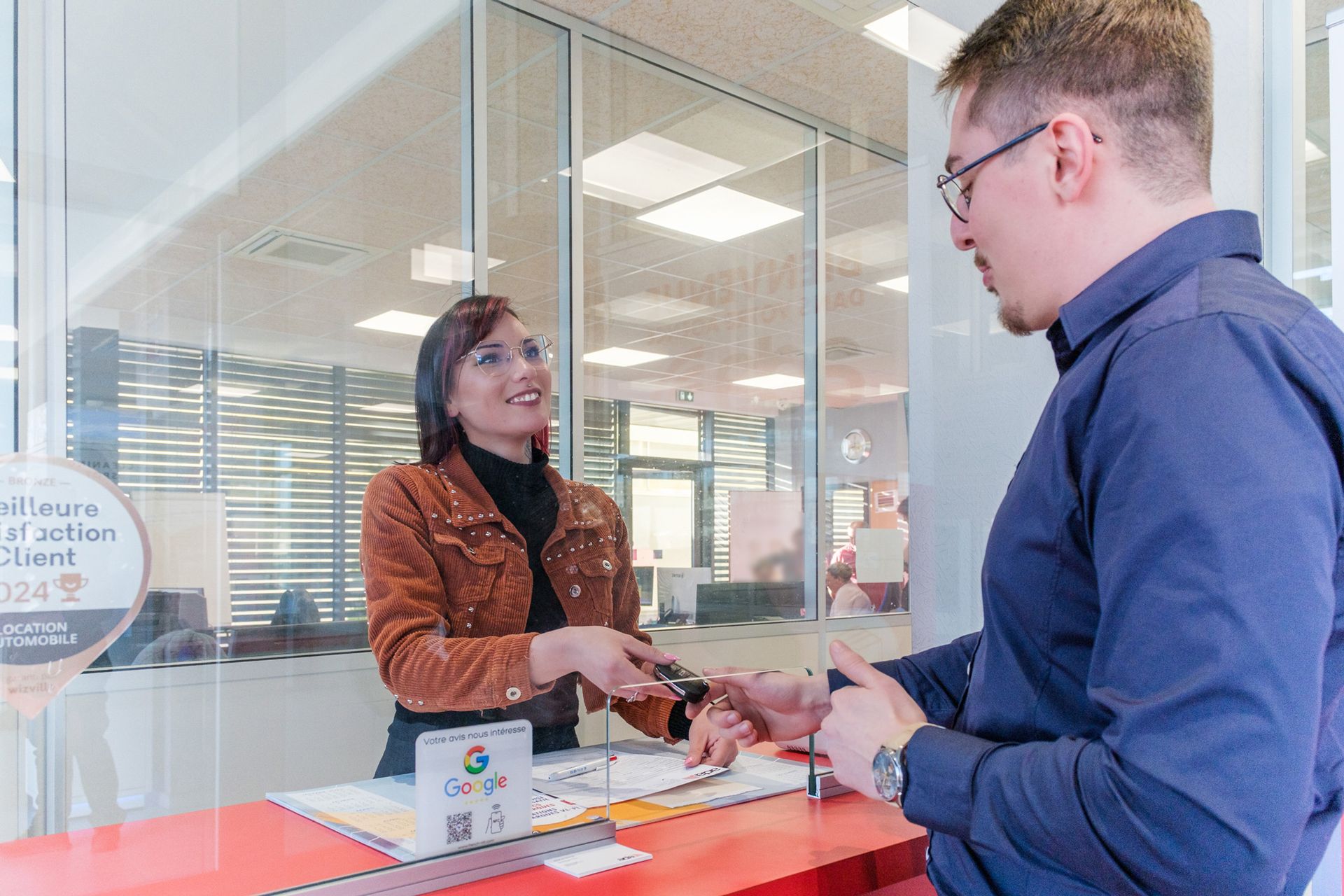 Une femme en train de remettre les clés à un client.
