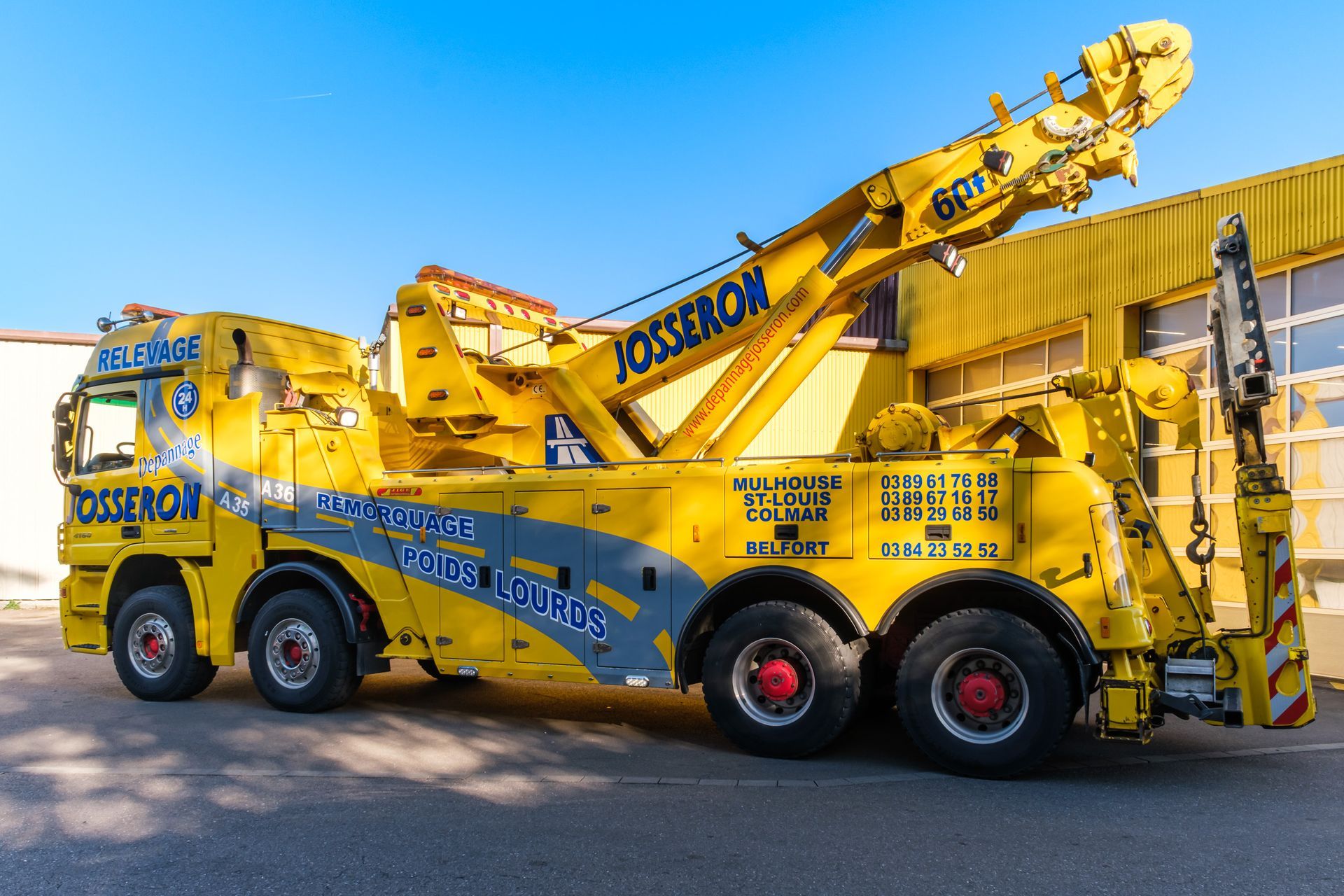 Véhicule poids lourd de dépannage jaune sur le parking.