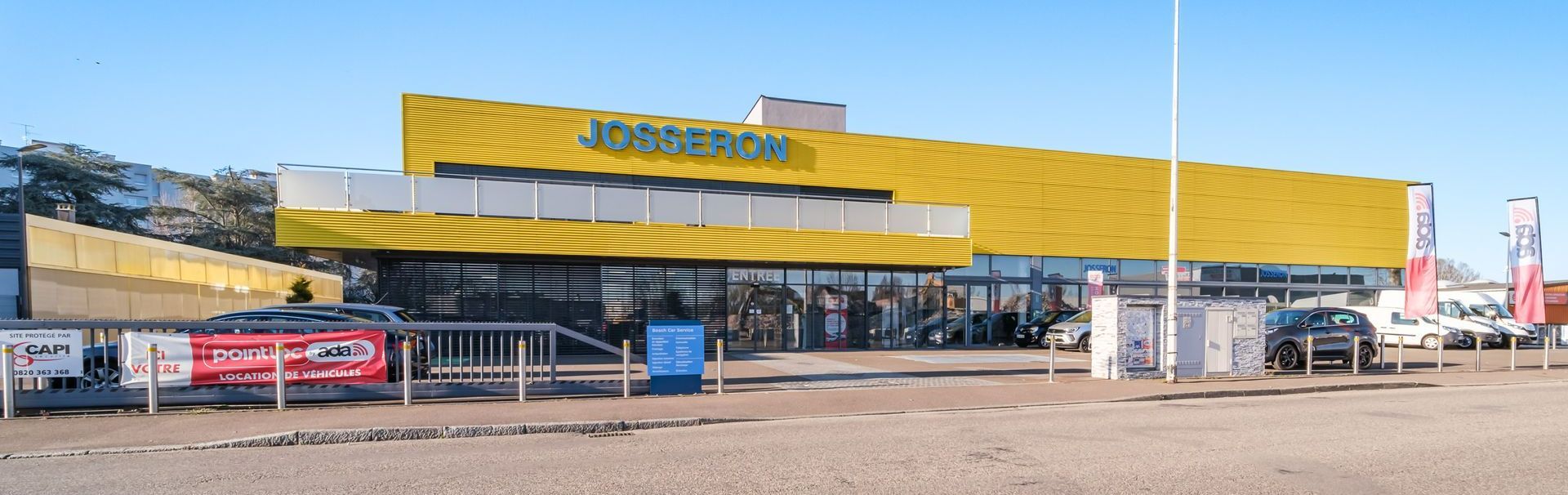 Grand bâtiment jaune où est inscrit Josseron en bleu.