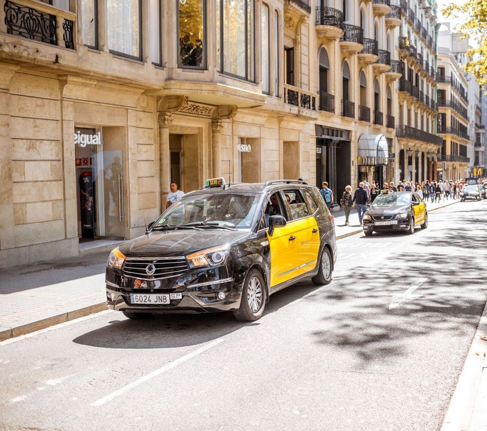 Un taxi negro y amarillo circula por una calle de la ciudad.