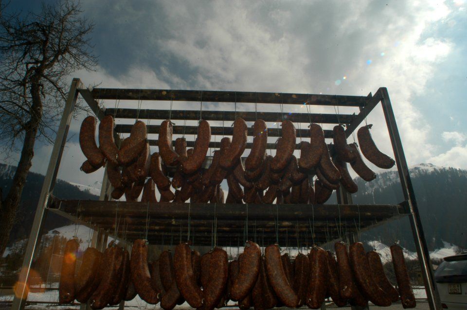 Aufgehängte Würste, Mitarbeiter bei der Wurstproduktion, Spezialitäten-Metzg Splügen, Strub Orlando