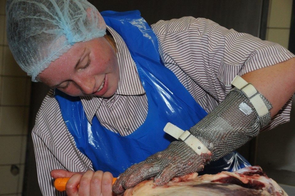 Frau schneidet Tierfüße, Mitarbeiter bei der Wurstproduktion, Spezialitäten-Metzg Splügen, Strub Orlando