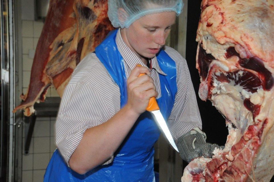 Frau schneidet Fleisch, Mitarbeiter bei der Wurstproduktion, Spezialitäten-Metzg Splügen, Strub Orlando
