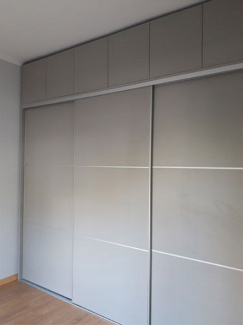 Un dormitorio con un gran armario con puertas correderas.