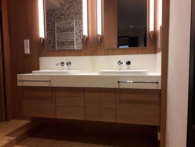 Un baño con dos lavabos y un espejo.