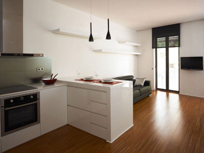 Una cocina con estufa, horno y sofá.